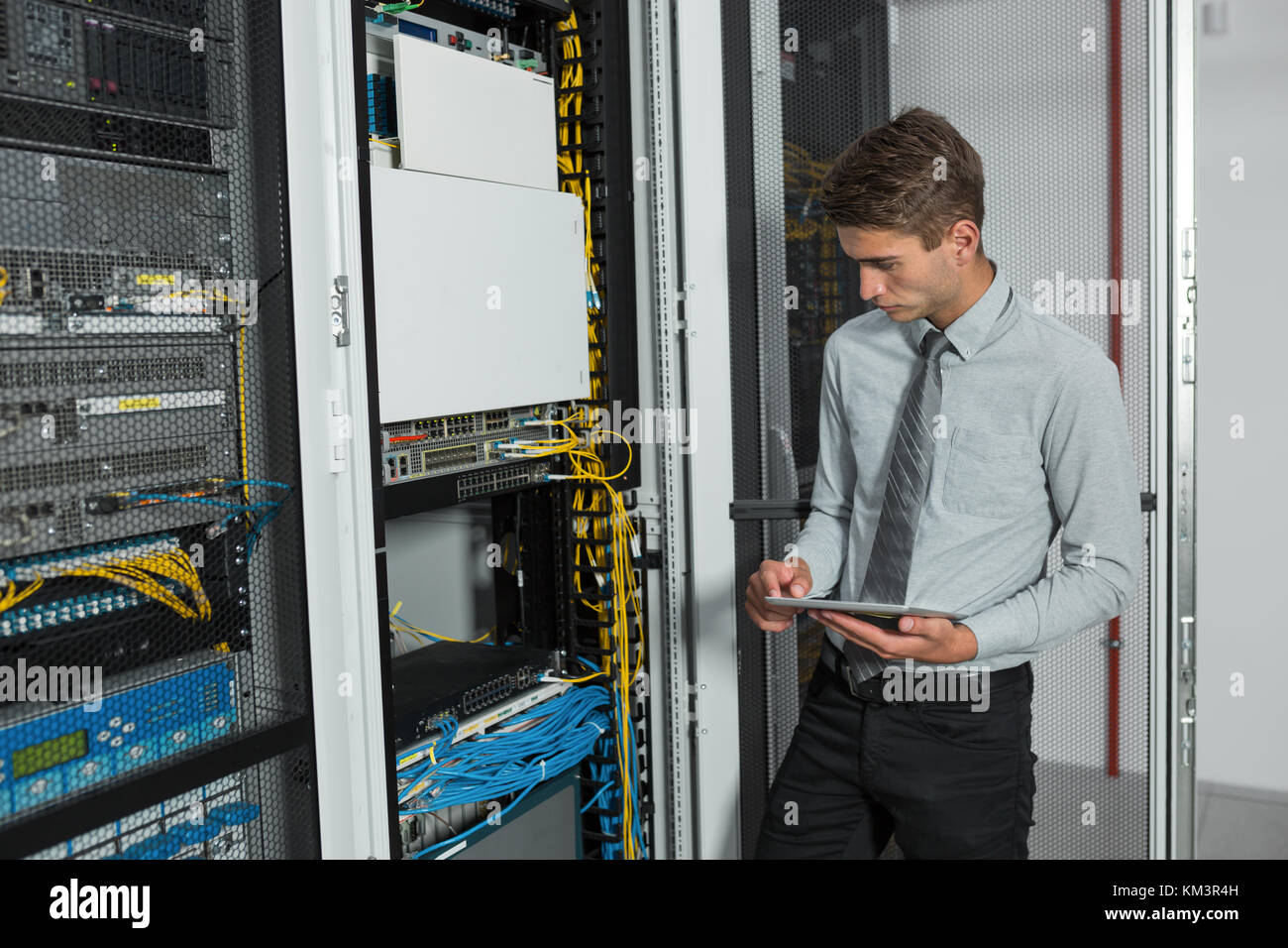 Young man is standing next to the racks with computer equipment Stock ...