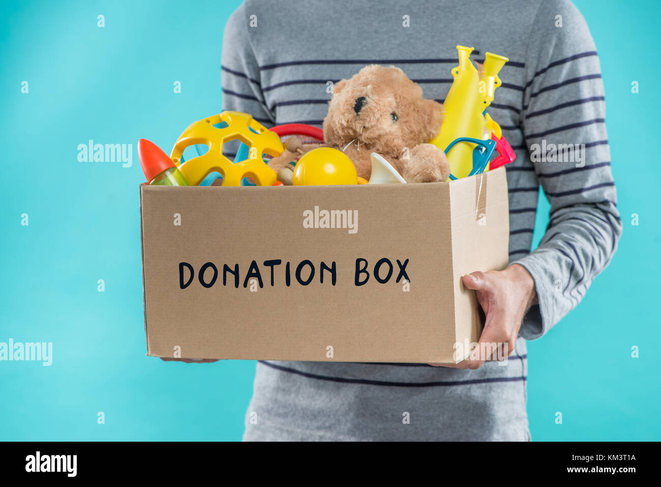 Male volunteer holding donation box with old toys Stock Photo Alamy
