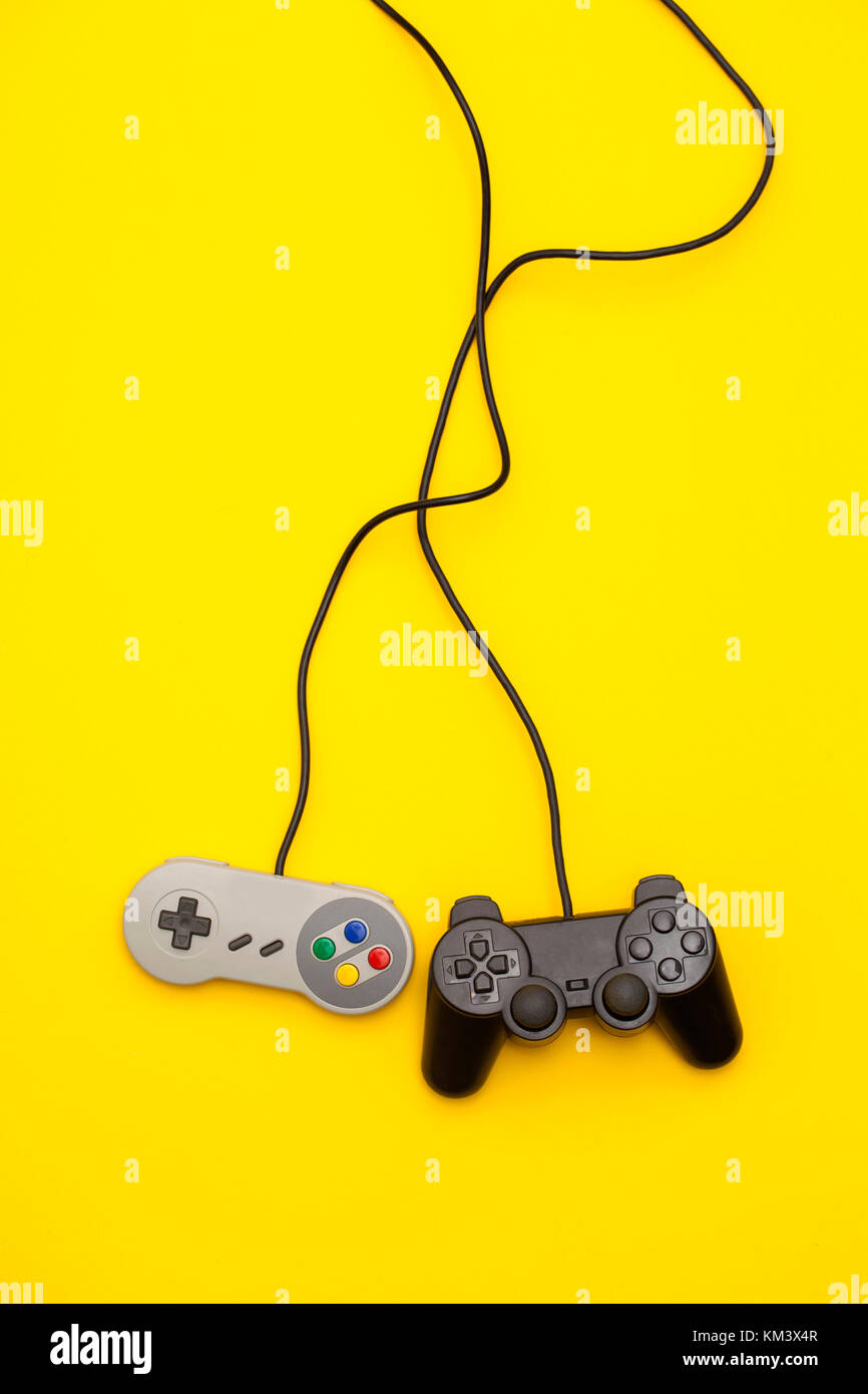 Retro computer gaming controllers on a bright yellow background Stock Photo