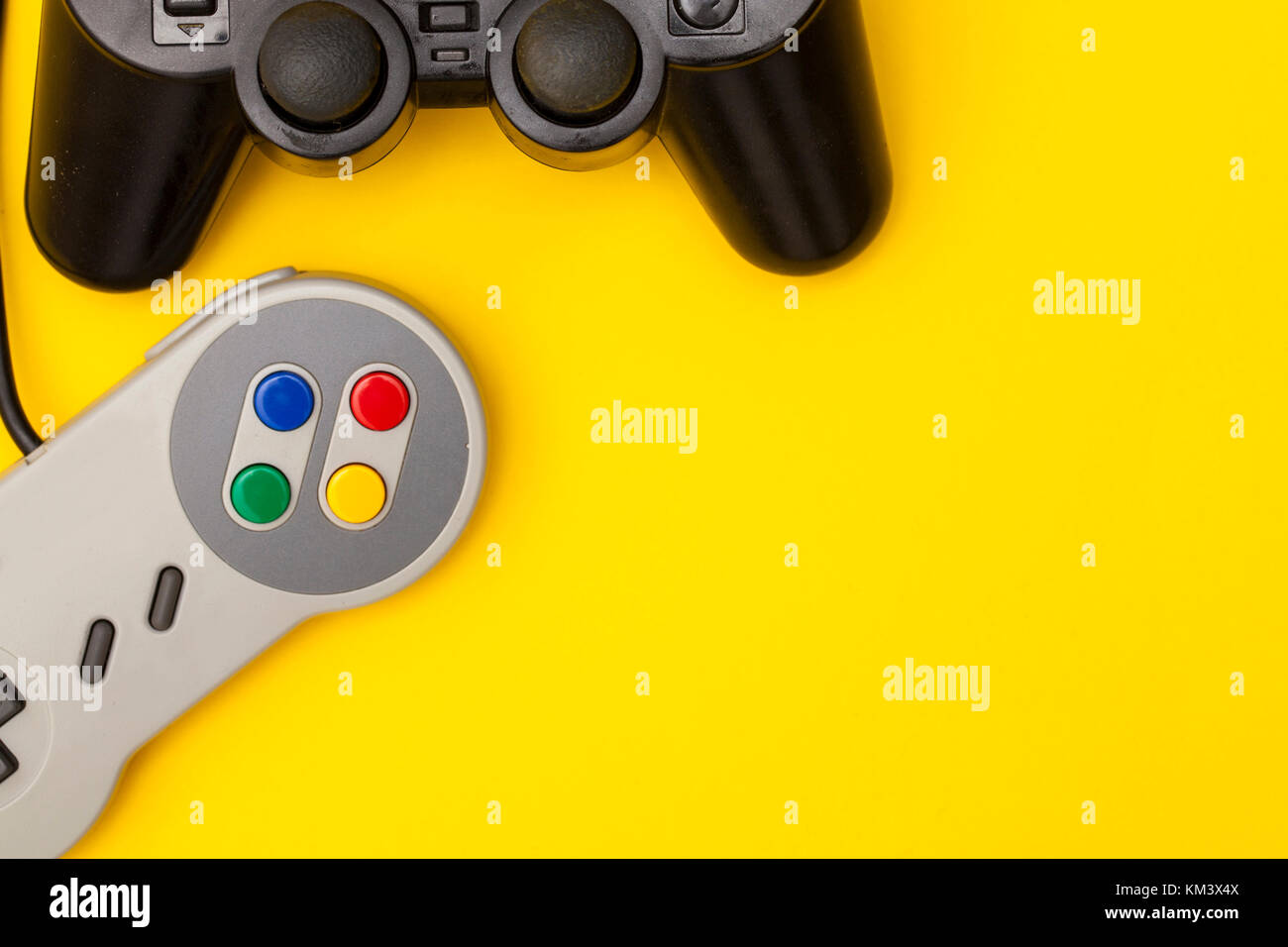 Retro computer gaming controllers on a bright yellow background Stock Photo