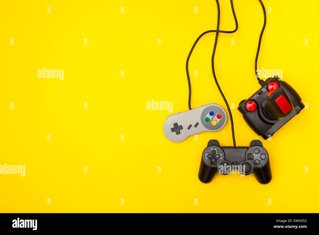 Retro computer gaming controllers on a bright yellow background Stock Photo
