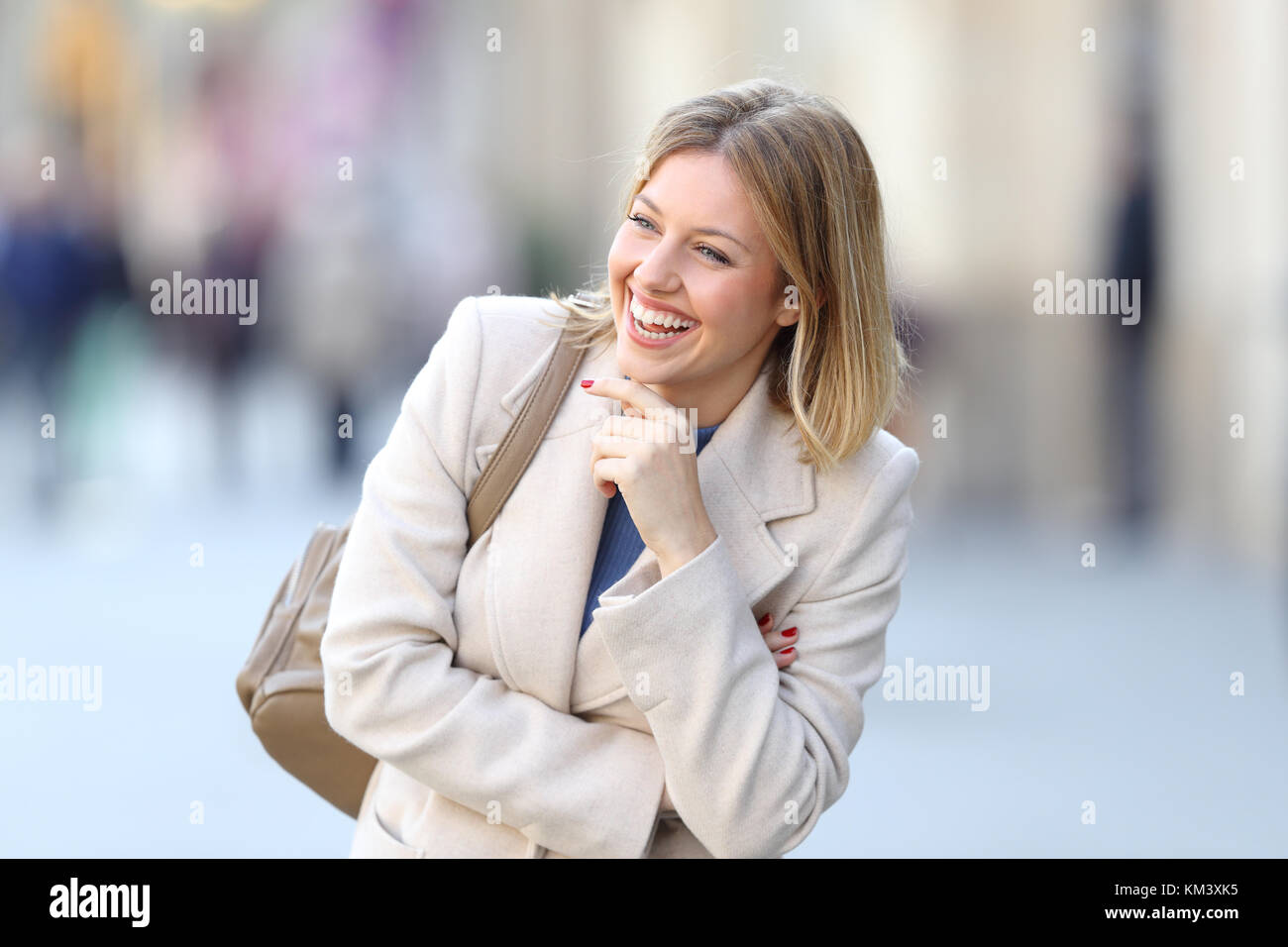 Portrait of a candid woman laughing alone on the street in winter Stock Photo