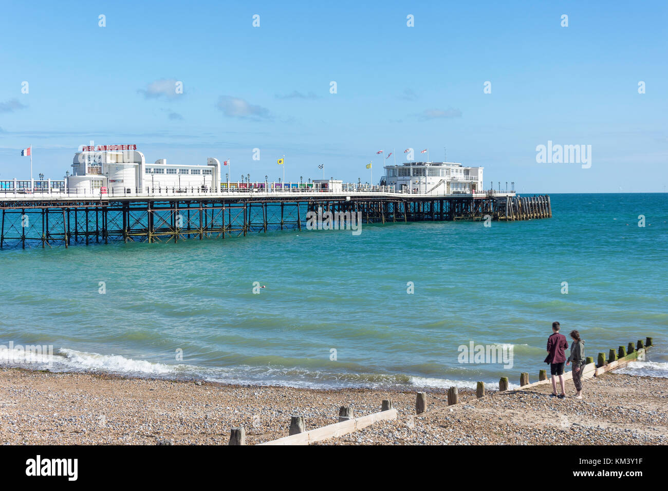 Young couple on beach and Worthing Pier,  Worthing, West Sussex, England, United Kingdom Stock Photo