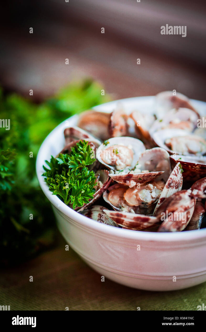 Bowl Of Delicious Fresh Steamer Clams With Garlic And Basil On Rustic