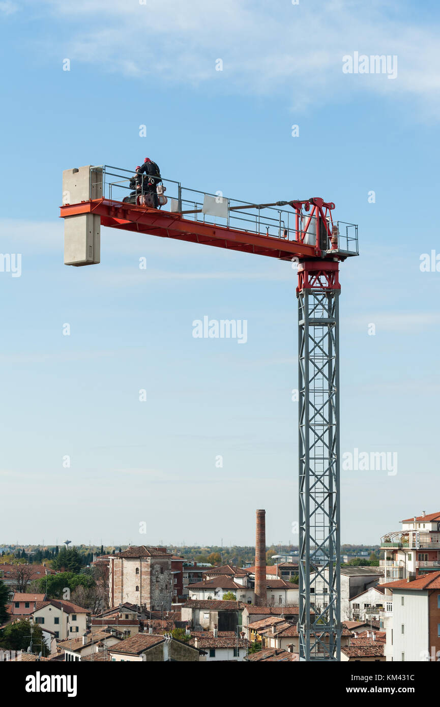 Unrecognizable technicians involved in the assembly of a construction crane. Stock Photo