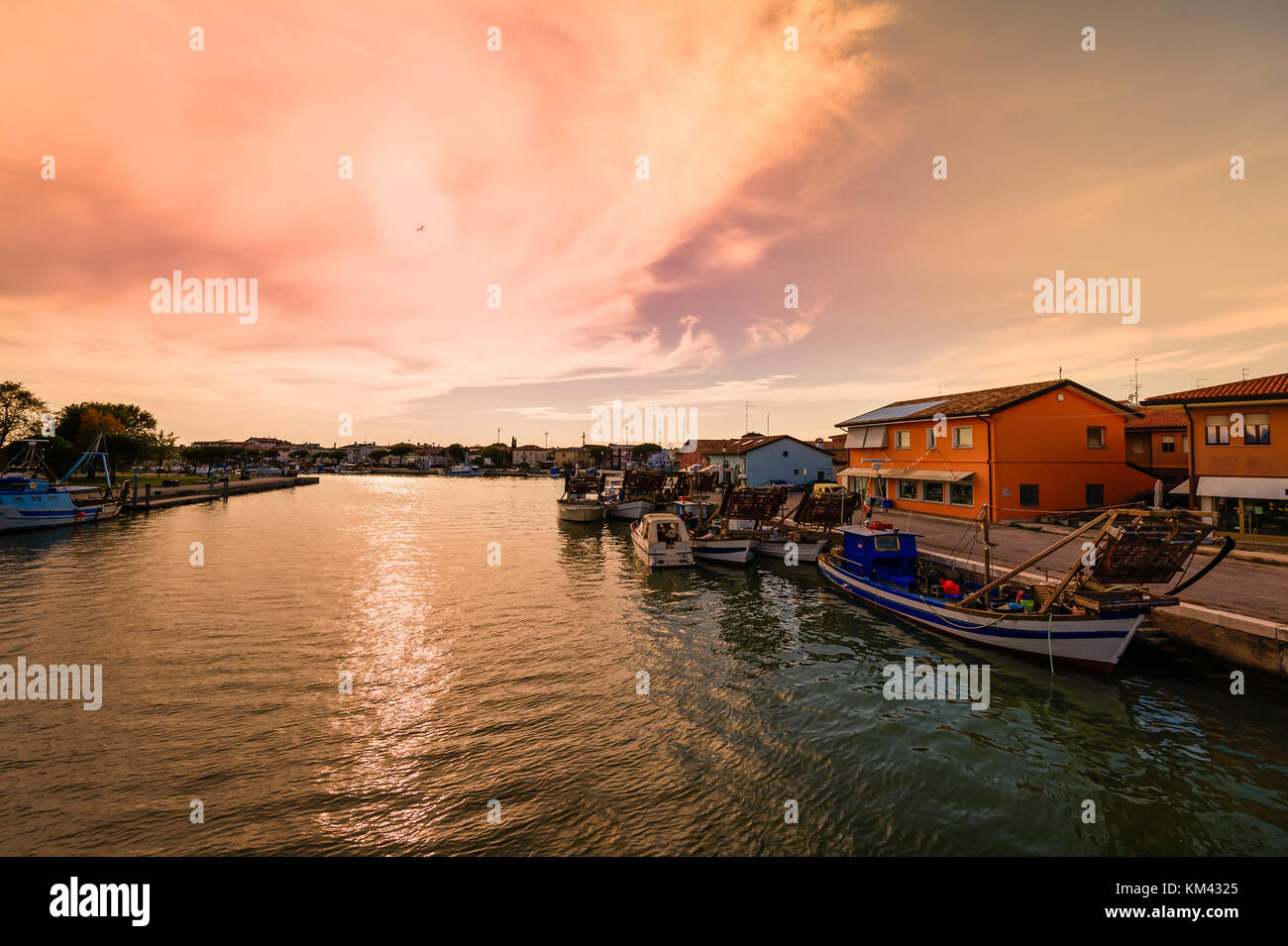 Fishing boats moored in the harbor at sunset. Stock Photo