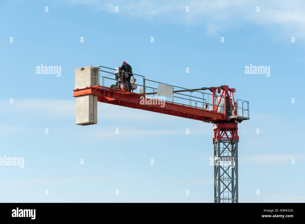 Unrecognizable technicians involved in the assembly of a construction crane. Stock Photo
