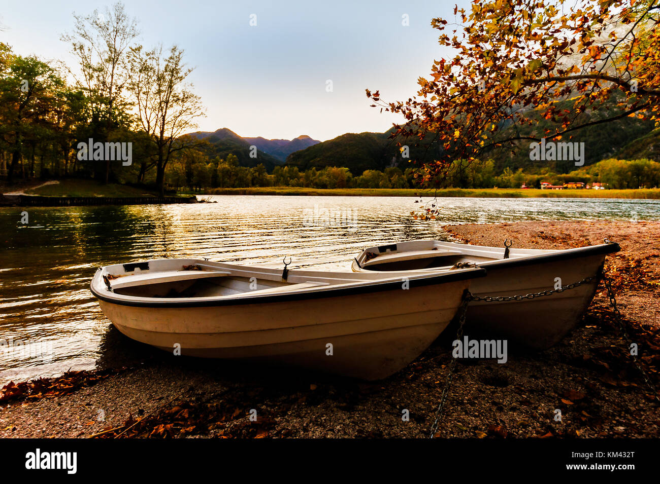 Two boats on the lake shore at sunset in autumn. Stock Photo