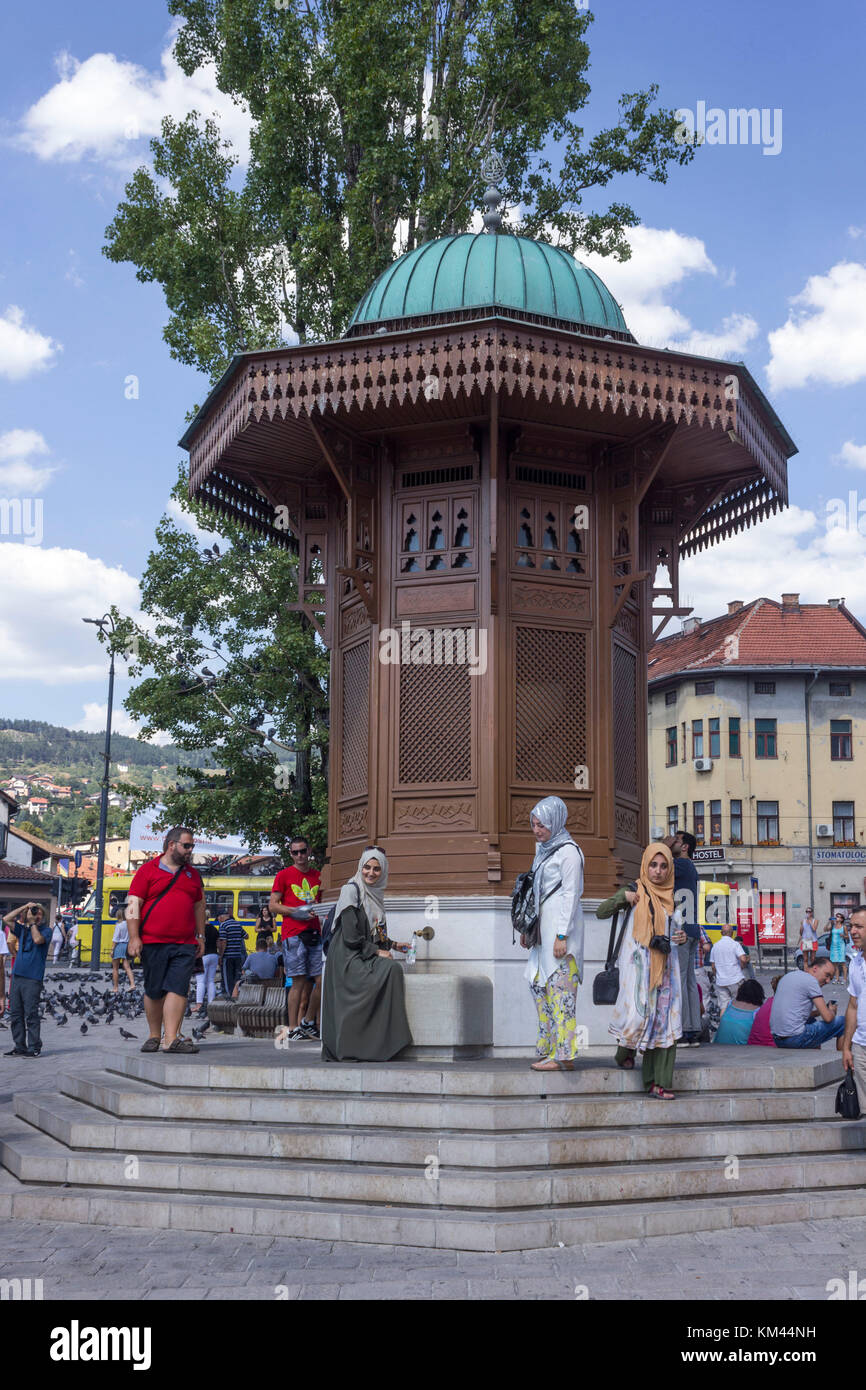 SARAJEVO, BOSNIA AND HERZEGOVINA - AUGUST 18 2017: Muslim gils taking water to the famous Sebilj fountain in Sarajevo city centre Stock Photo