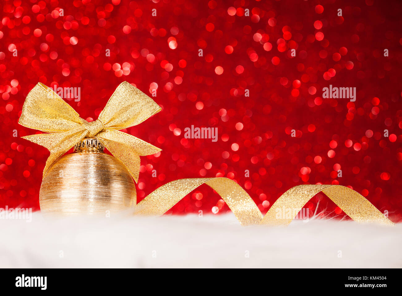 Christmas gold ball and bow on red glitter shiny background Stock Photo ...