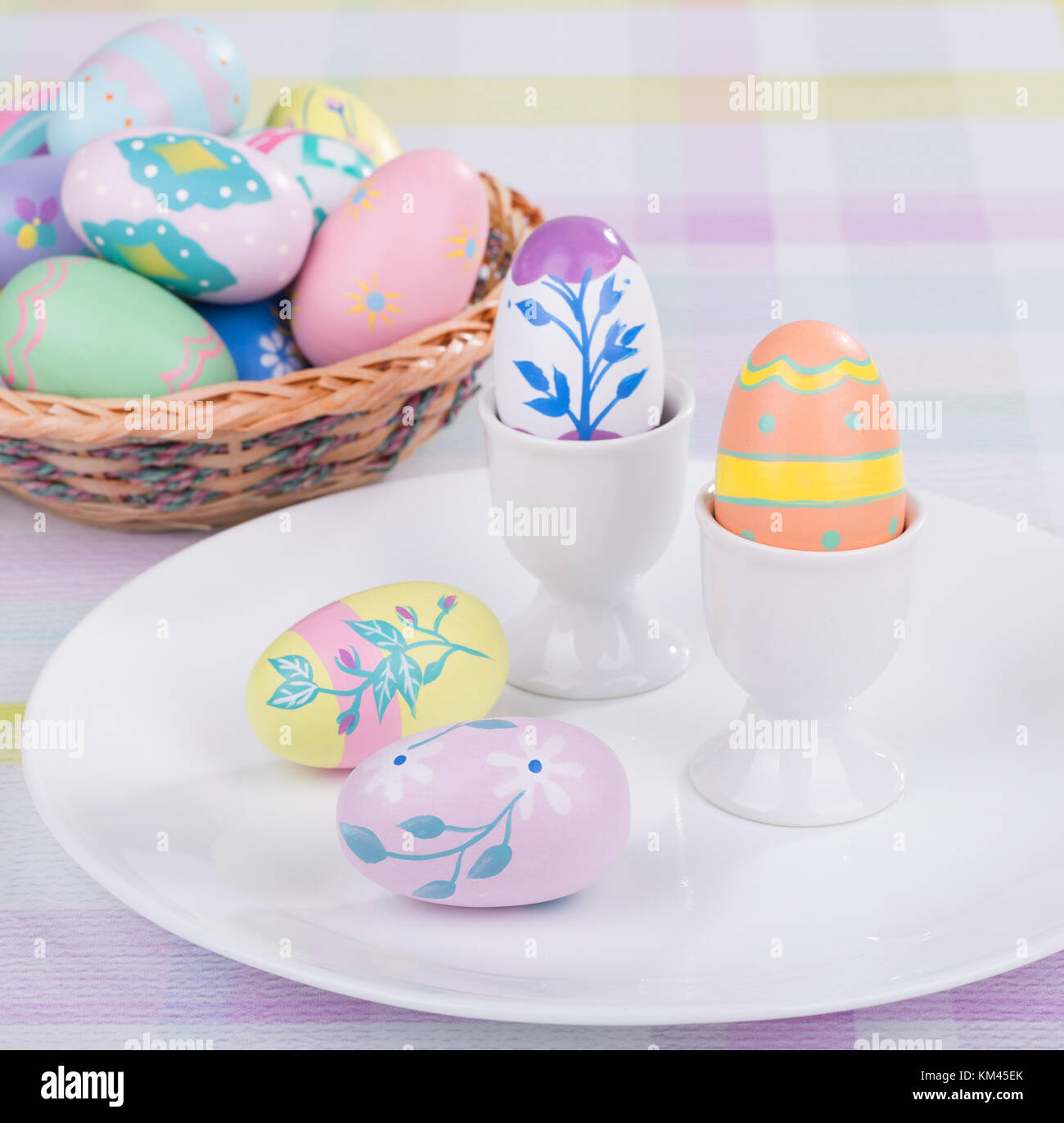 Decorative Easter Eggs On A Plate With Egg Cups And Basket Stock