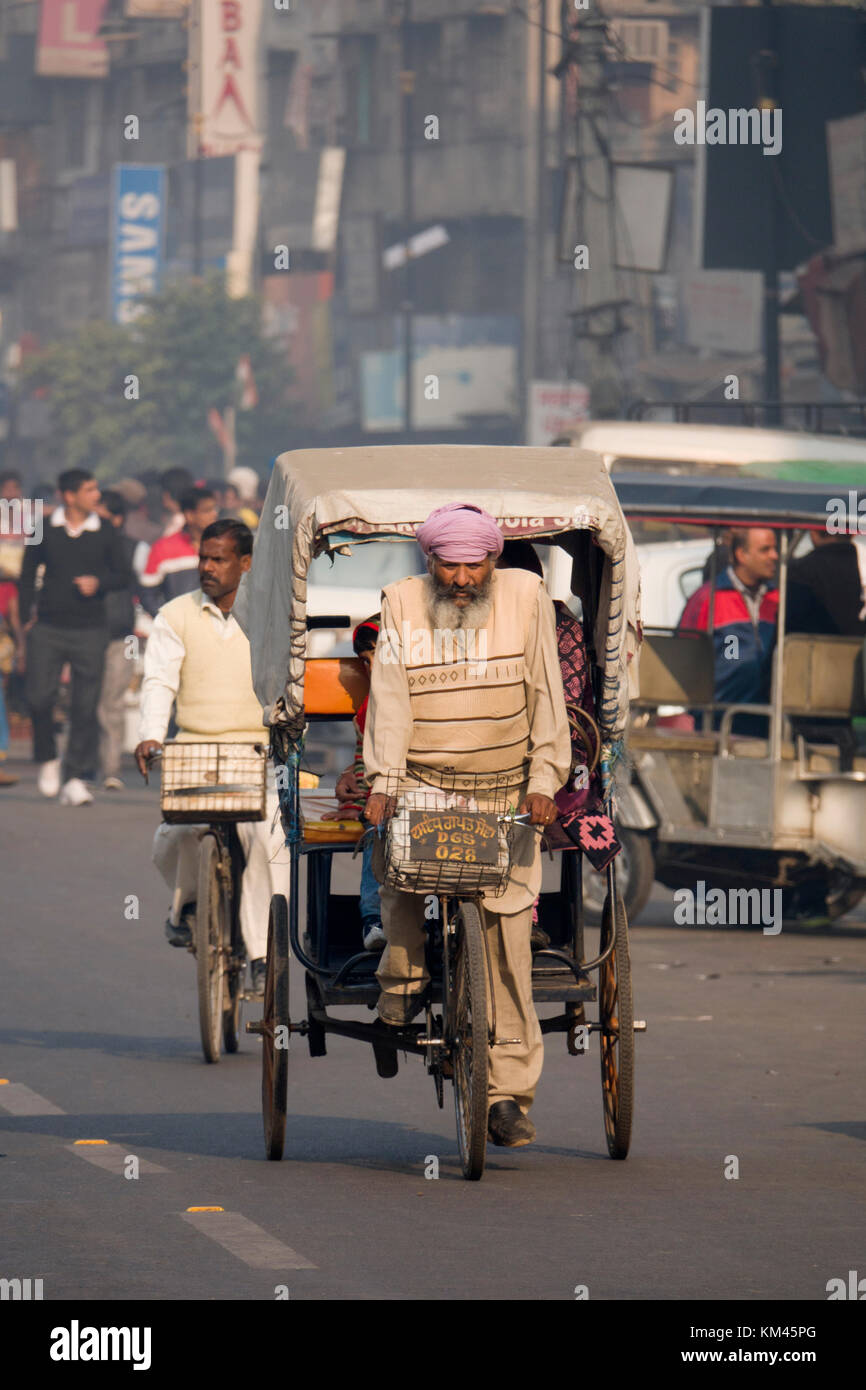 Bearded Punjabi Sikh man riding cycle rickshaw in Amritsar, India Stock Photo