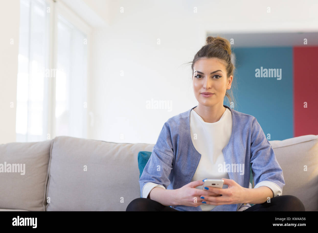 young happy woman using mobile phone on sofa at luxury home Stock Photo ...