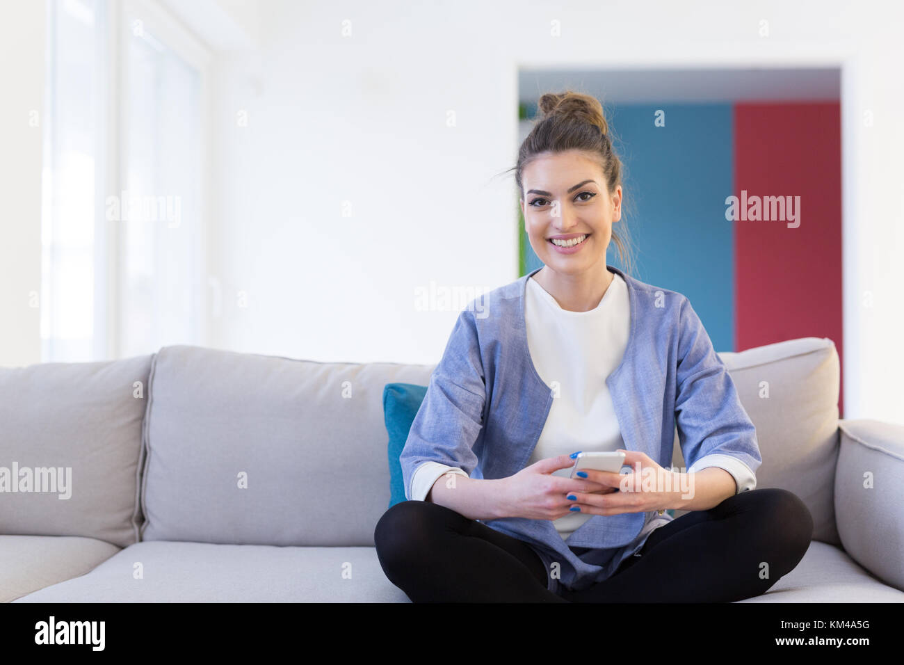 young happy woman using mobile phone on sofa at luxury home Stock Photo ...