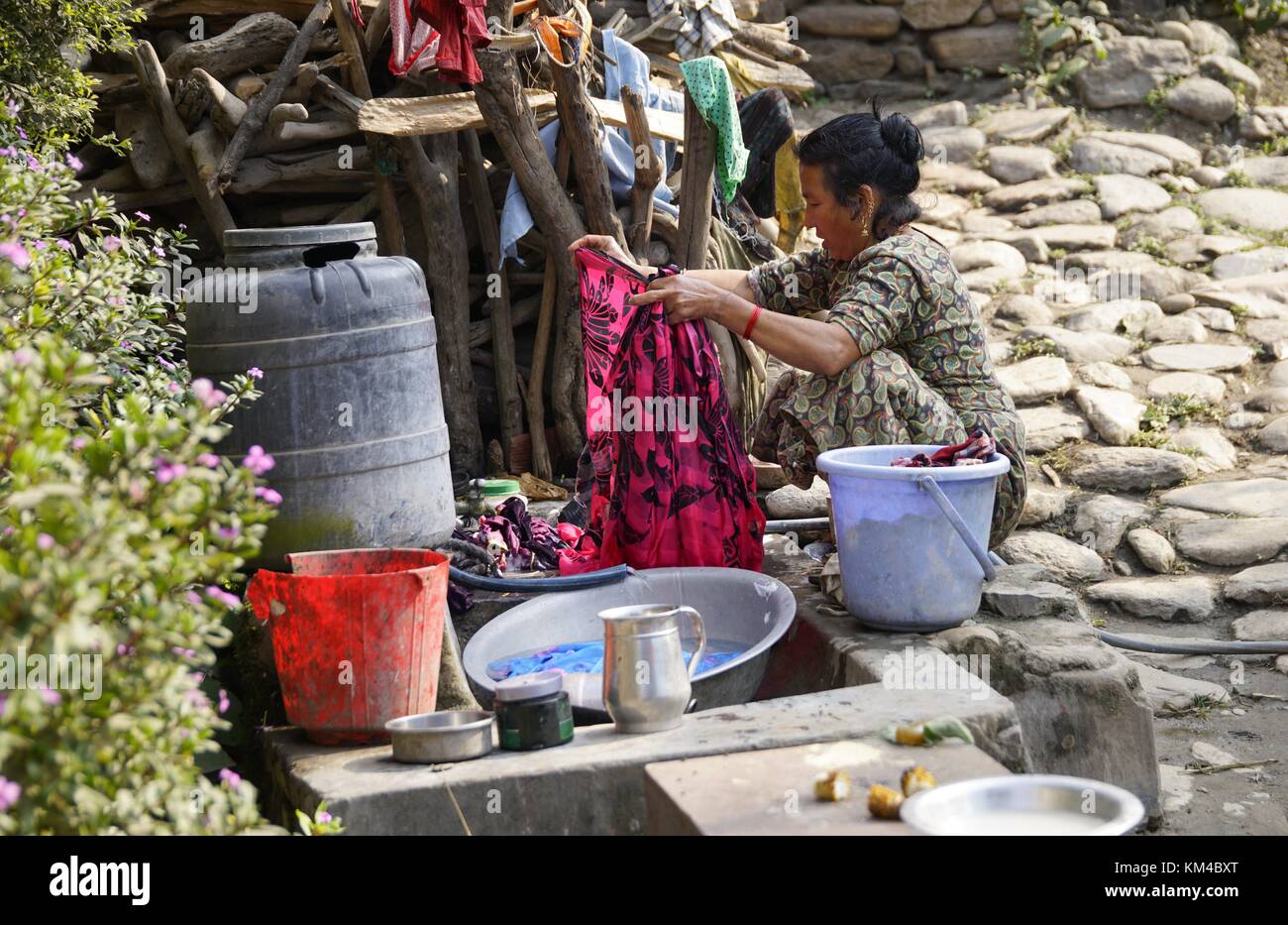 A woman washes laundry on a typical washing place on a street near