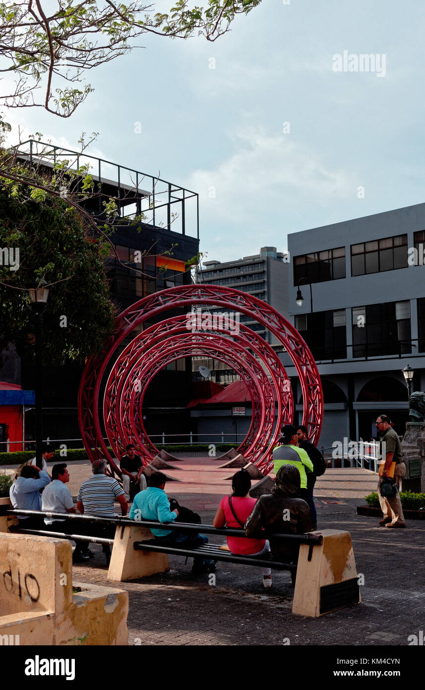 Two red wheels form art in a plaza square, San Jose, Costa Rica Stock Photo
