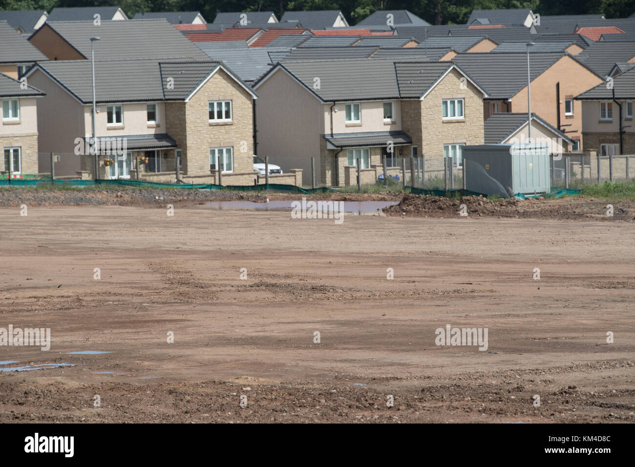 new houses on brownfield site in Scotland UK with new site in foreground ready for new house building Bishopton on reclaimed land Stock Photo