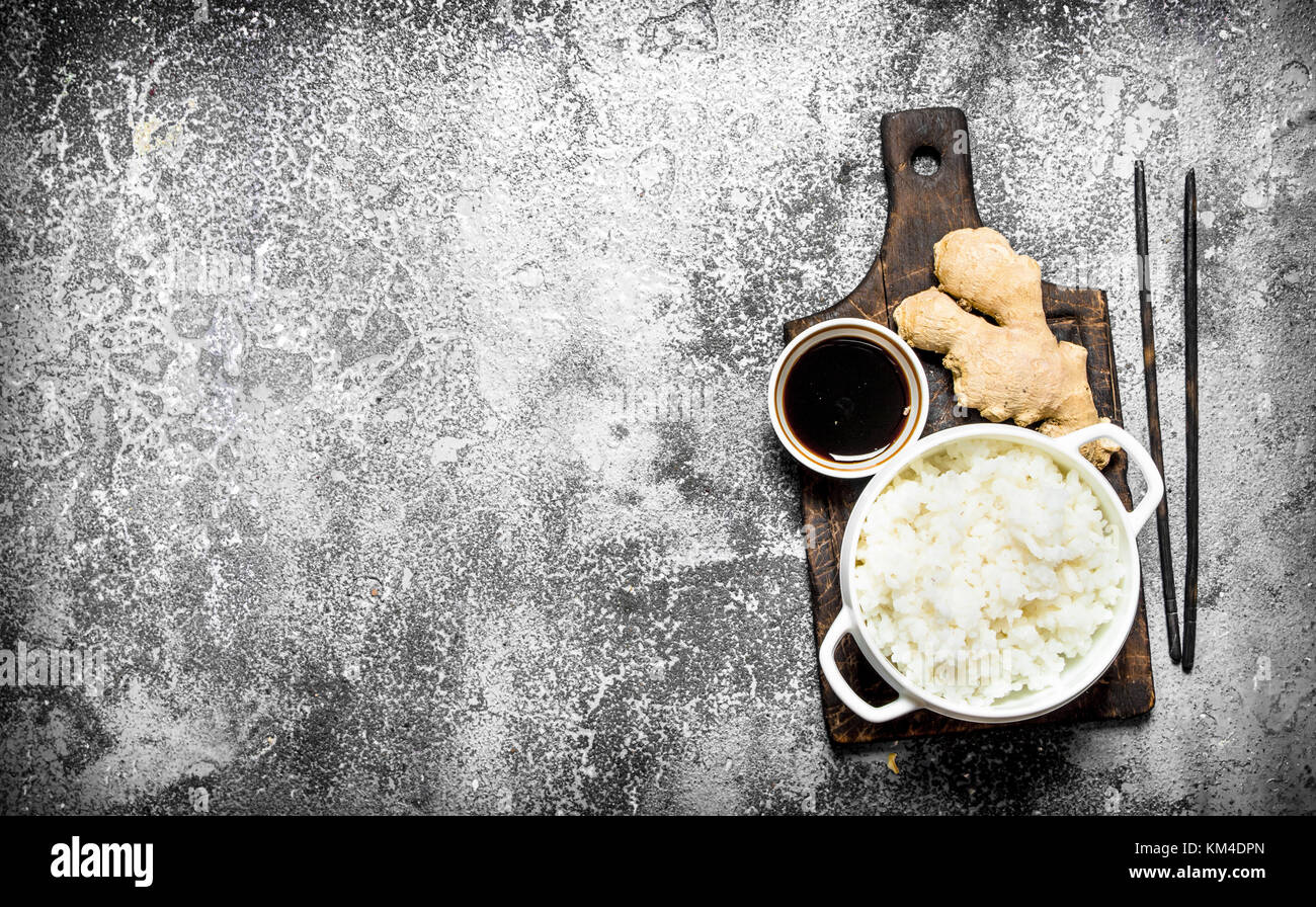 Asian food. Boiled rice with soy sauce on the old Board. On rustic ...