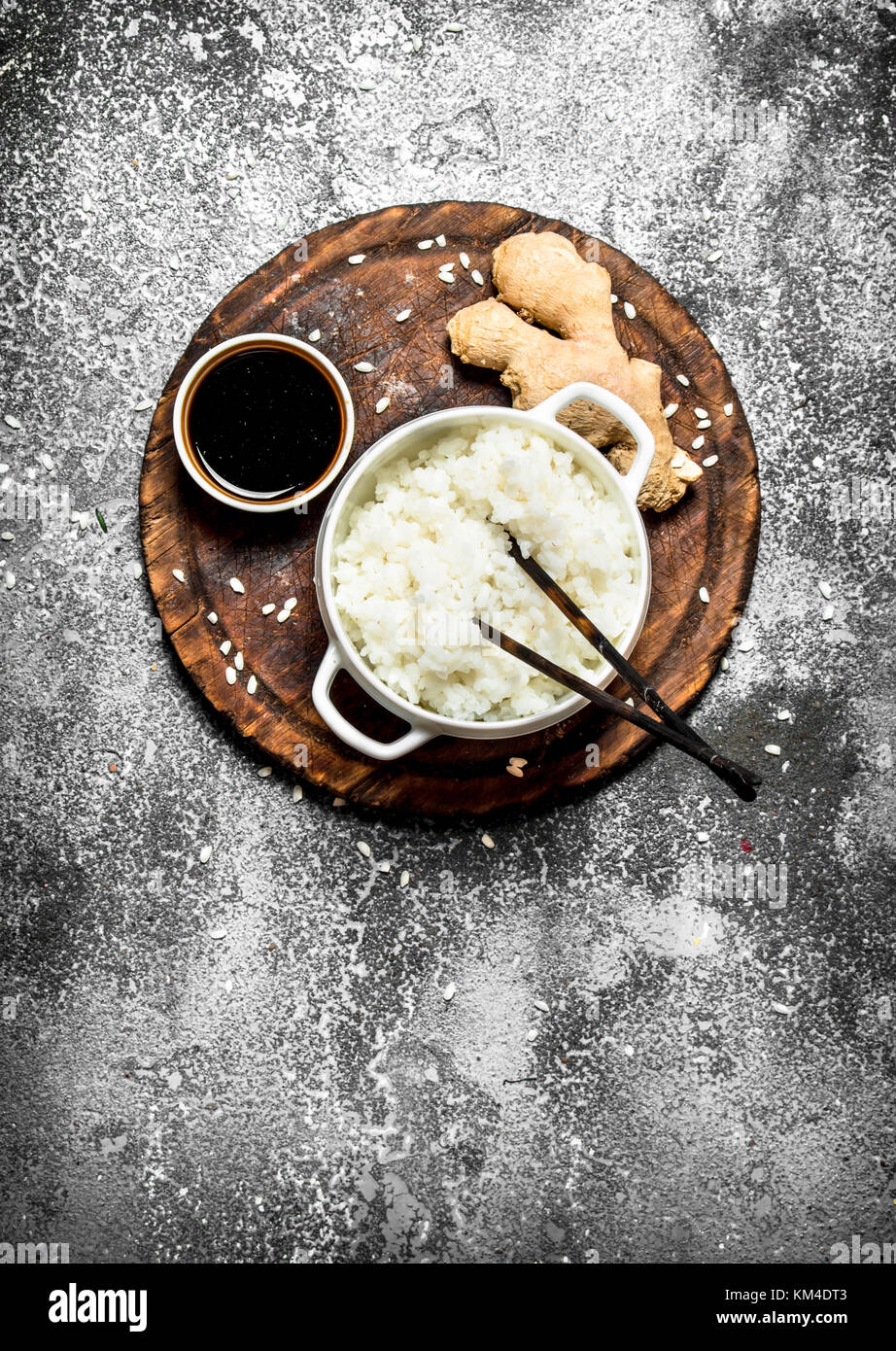 Asian food. Boiled rice with soy sauce on the old Board. On rustic ...