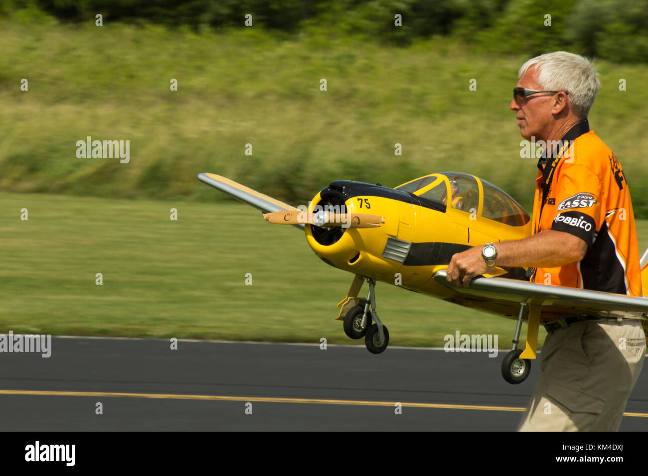Pilot caring a prop place on runway. Stock Photo
