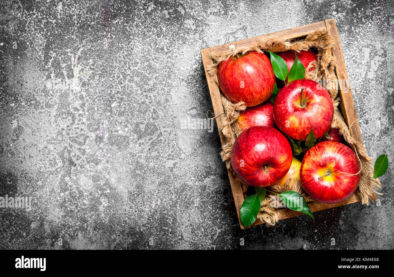 Red apples in an old box. On rustic background Stock Photo - Alamy