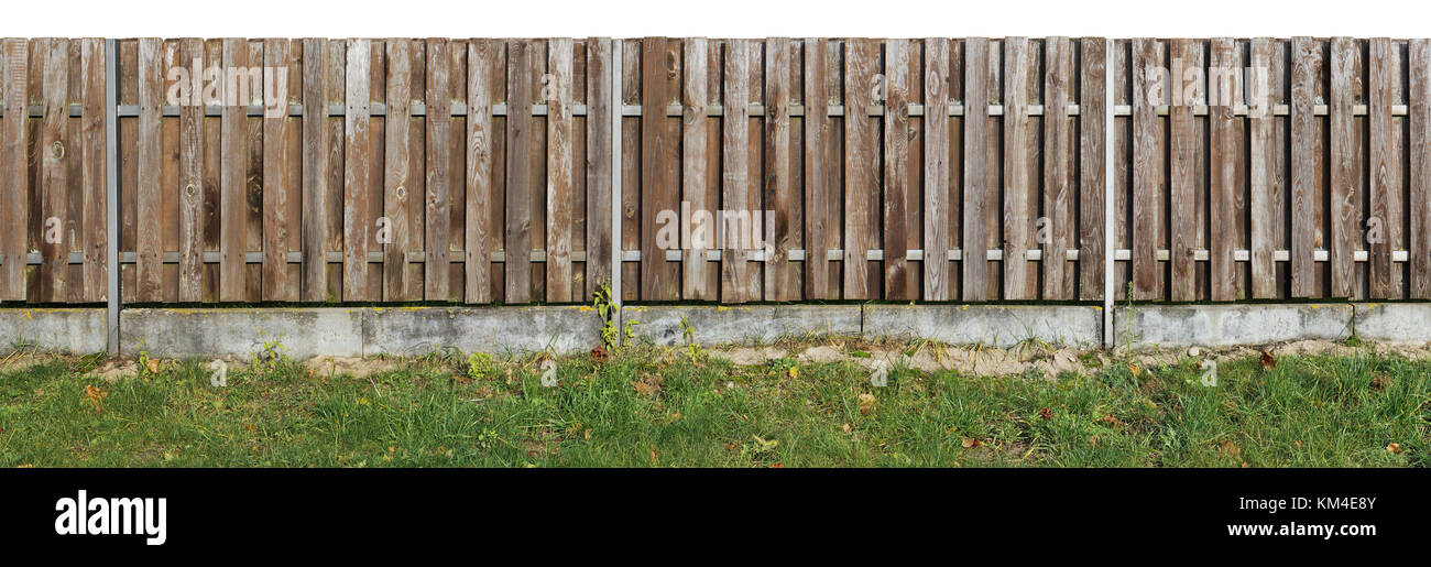 Long old solid aged   brown  wooden rural fence from vertical pine planks. Base made from cimple concrete. Isolated on white  panoramic collage Stock Photo