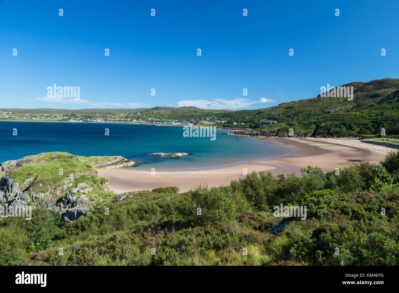 View over a sandy beach and loch Gairloch towards Gairloch in the North West Highlands of Scotland Stock Photo