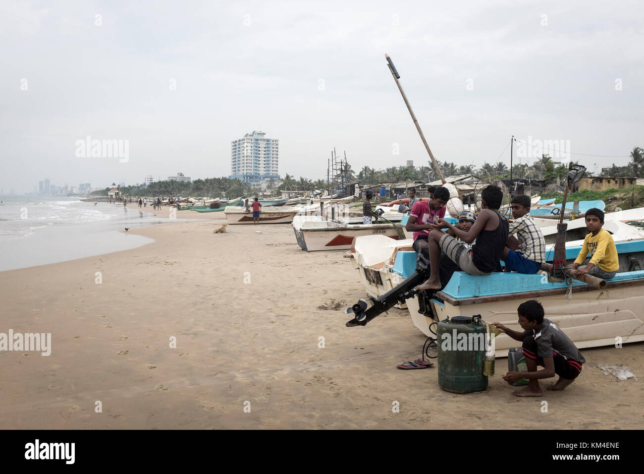 Fishermen tend to their boats on the beach in Colombo, Sri Lanka Stock Photo