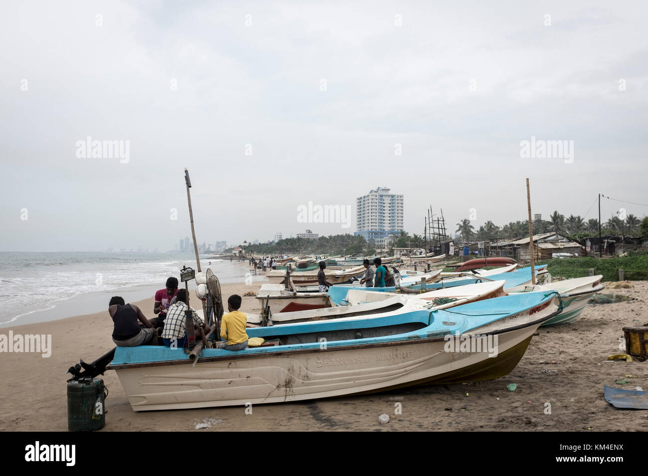 Fishermen tend to their boats on the beach in Colombo, Sri Lanka Stock Photo