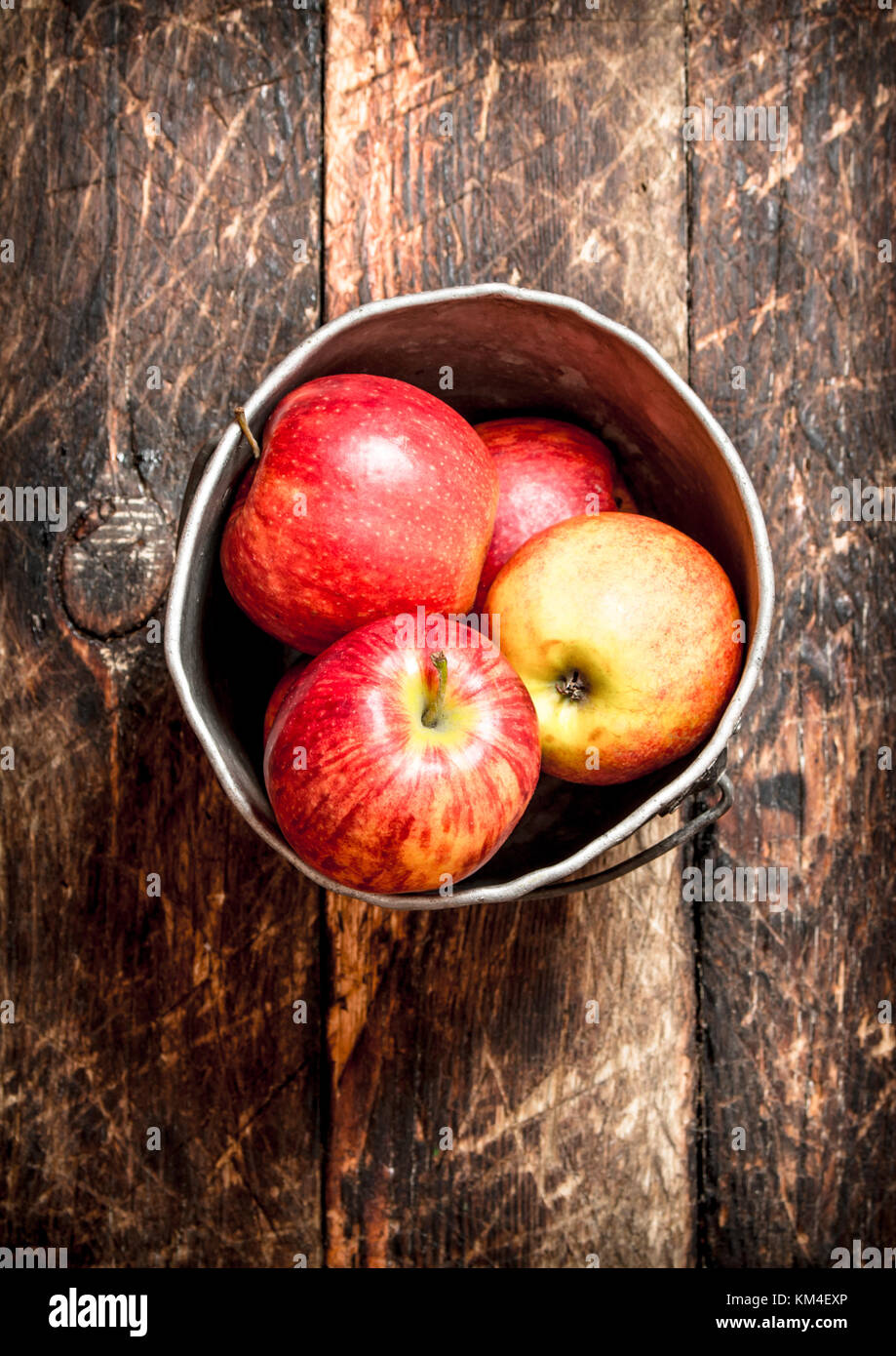 Red apples in an old bucket. On wooden background Stock Photo - Alamy