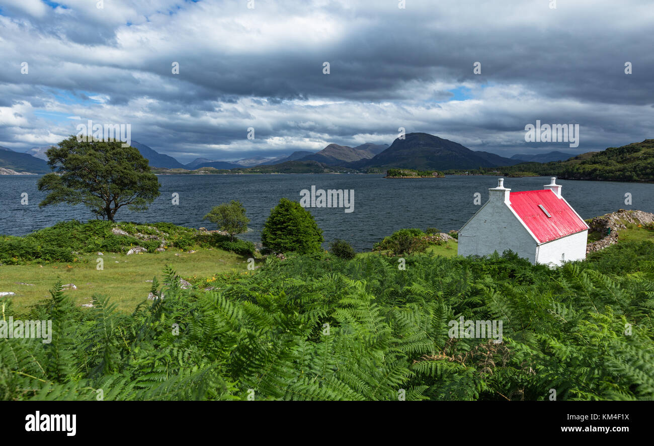 Remote cottage overlooking Loch Shieldaig and Loch Torridon beyond in the North West Highlands of Scotland Stock Photo