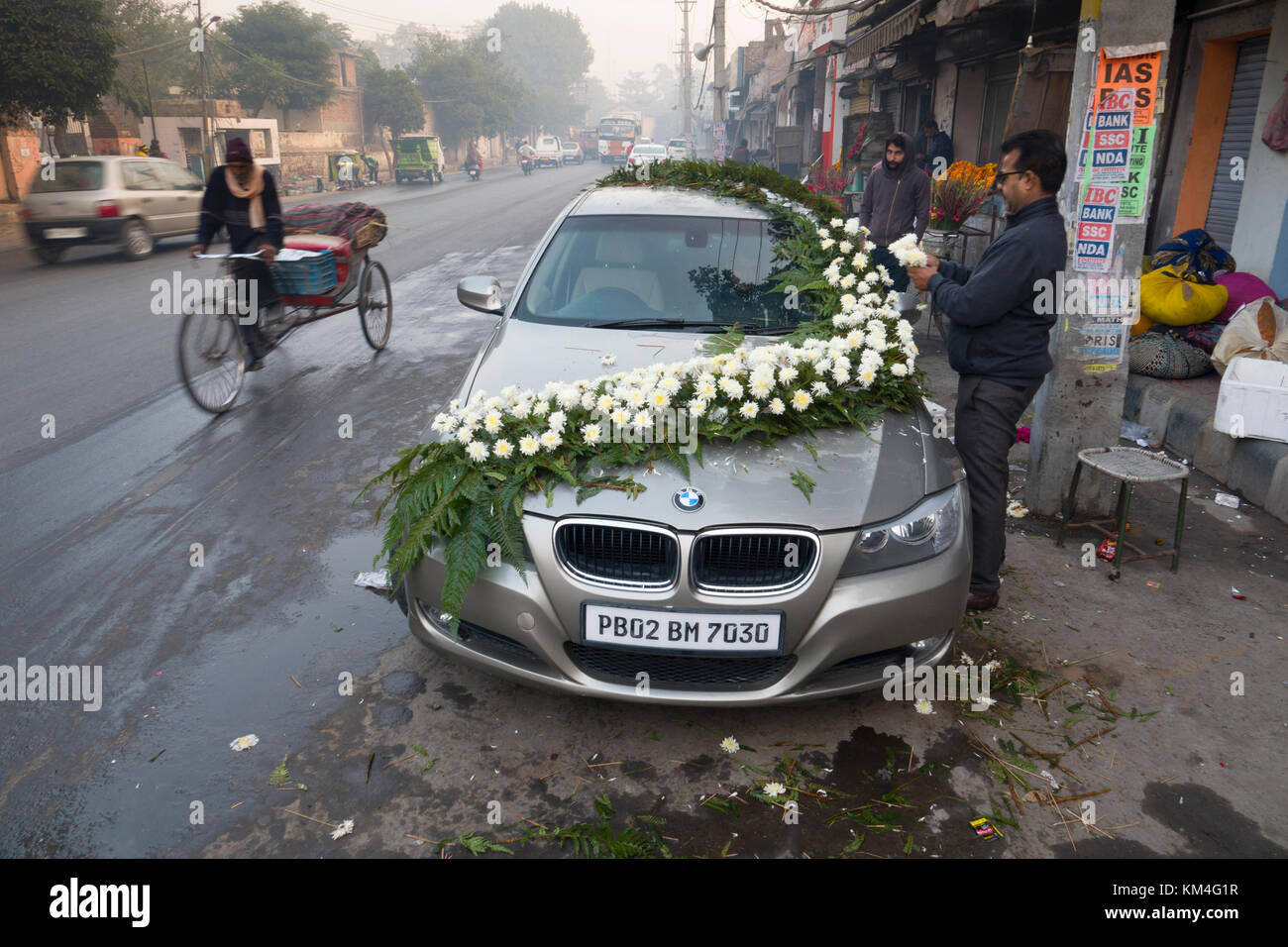 Man decorates wedding car with floral arrangement in Amritsar, India Stock Photo
