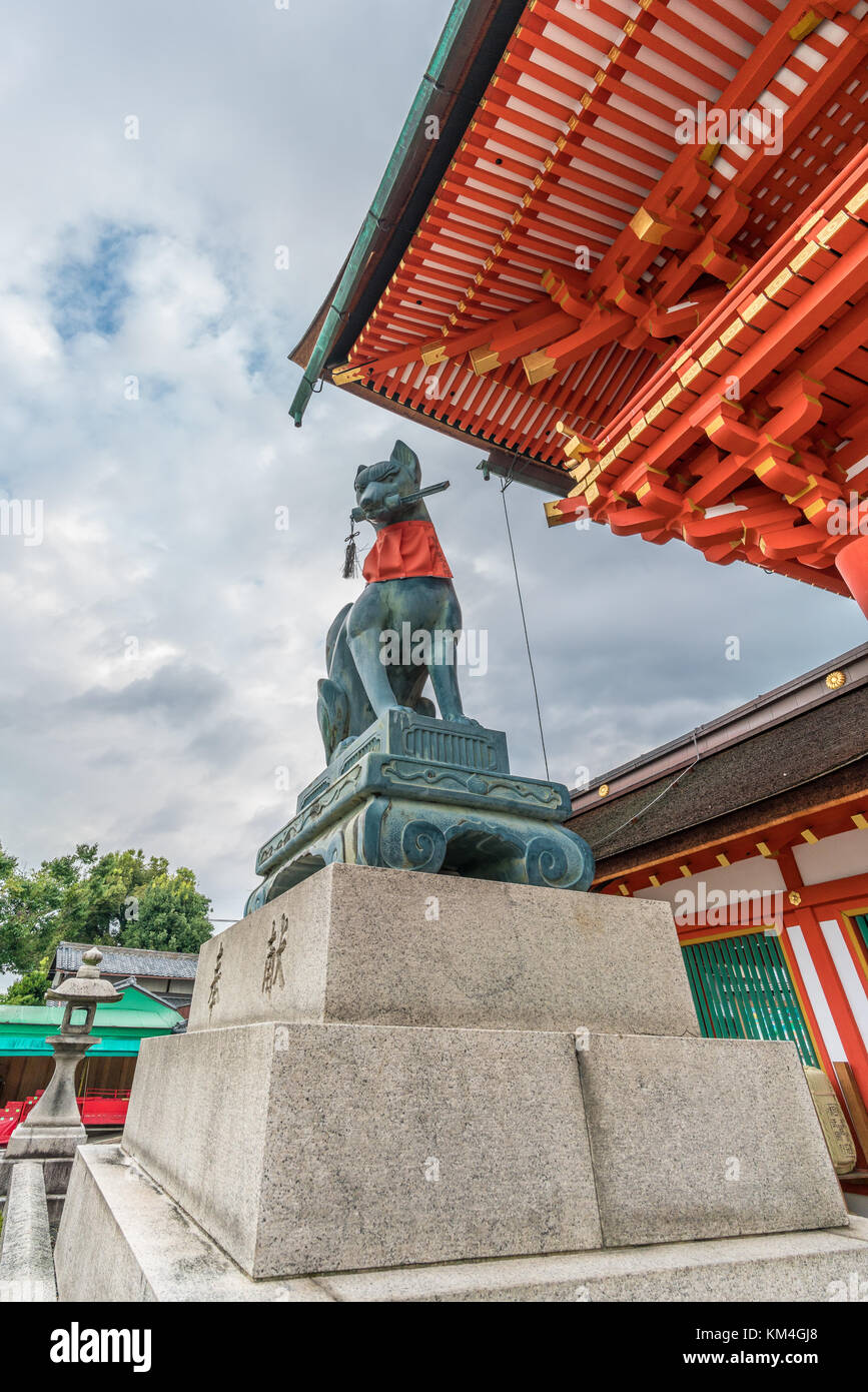 Inari (Fox) statues at Romon or Roumon (Tower Gate) of Fushimi Inari Taisha Shinto shrine. Houken (Consecration or Offering) Inscription in the pedest Stock Photo
