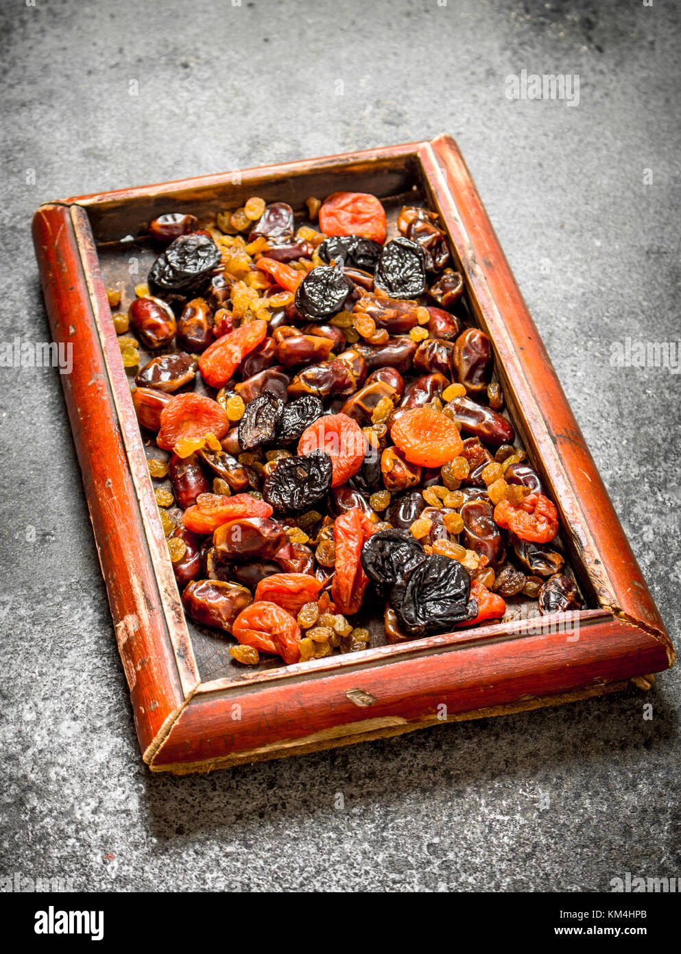 Various dried fruits in tray. On rustic background . Stock Photo