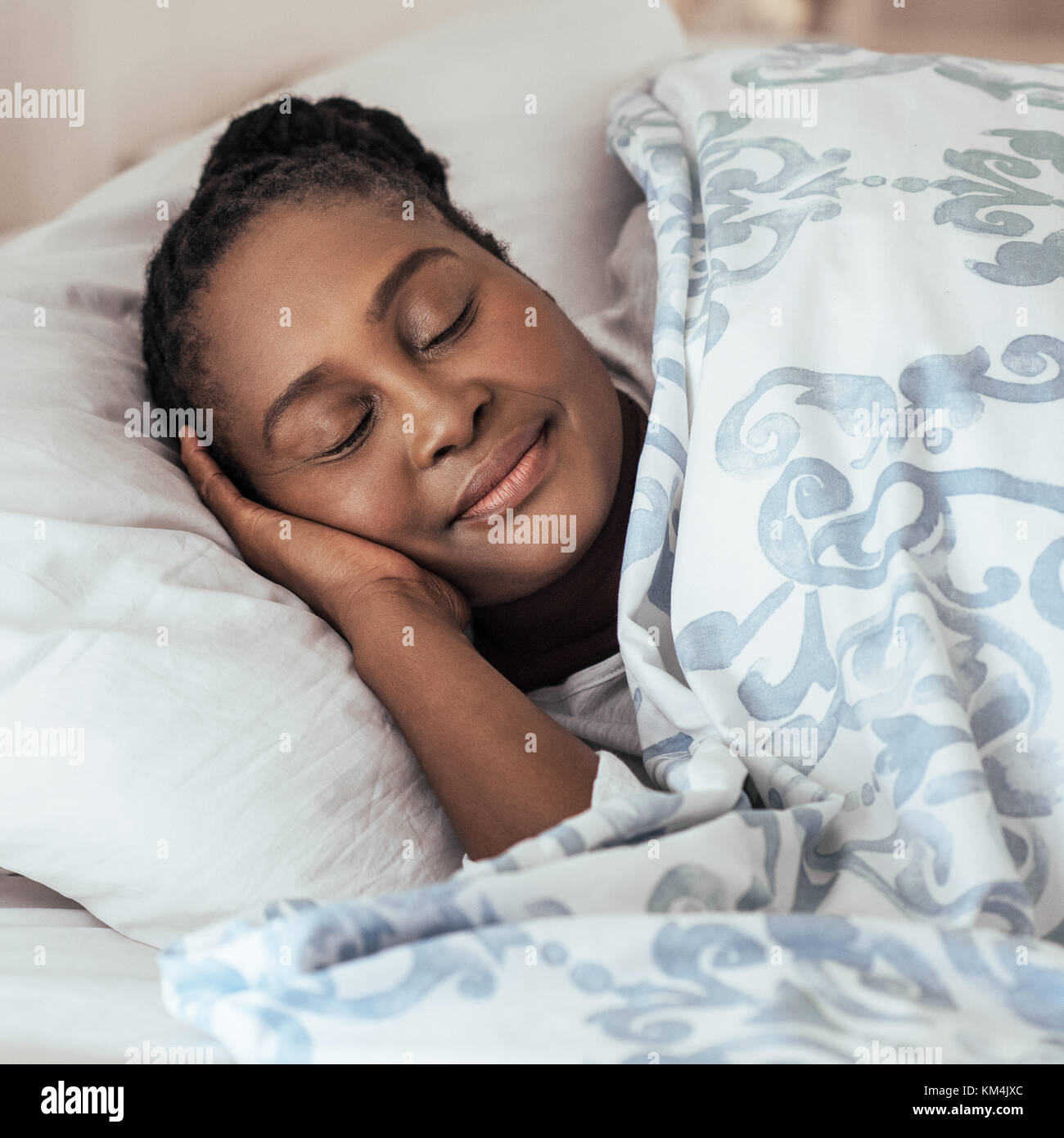 Mature African woman fast asleep in her bed at home Stock Photo