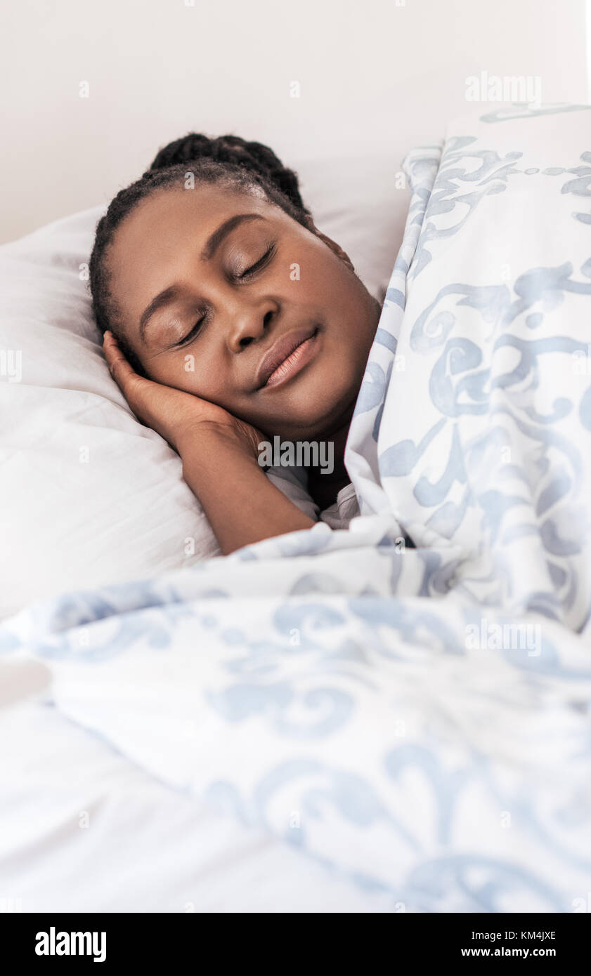 Young African woman lying in her bed sleeping Stock Photo