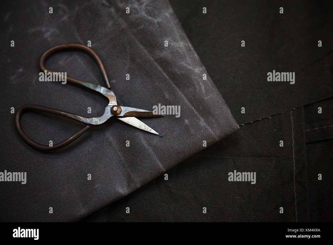 A pile of cut denim and hard wearing fabrics marked up for remaking