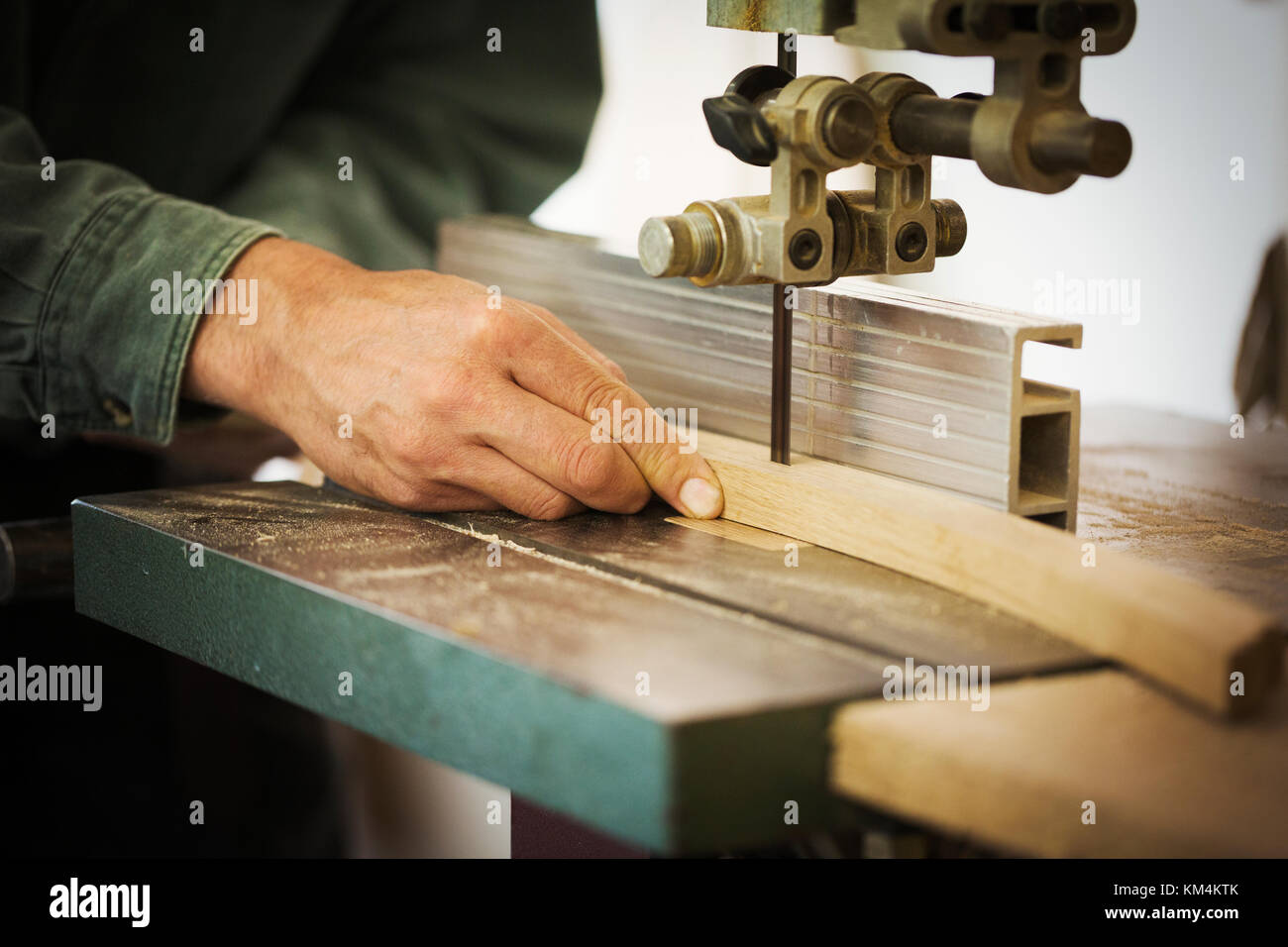 A craftsman using a machine drill on a piece of smooth planed shaped wood. Stock Photo