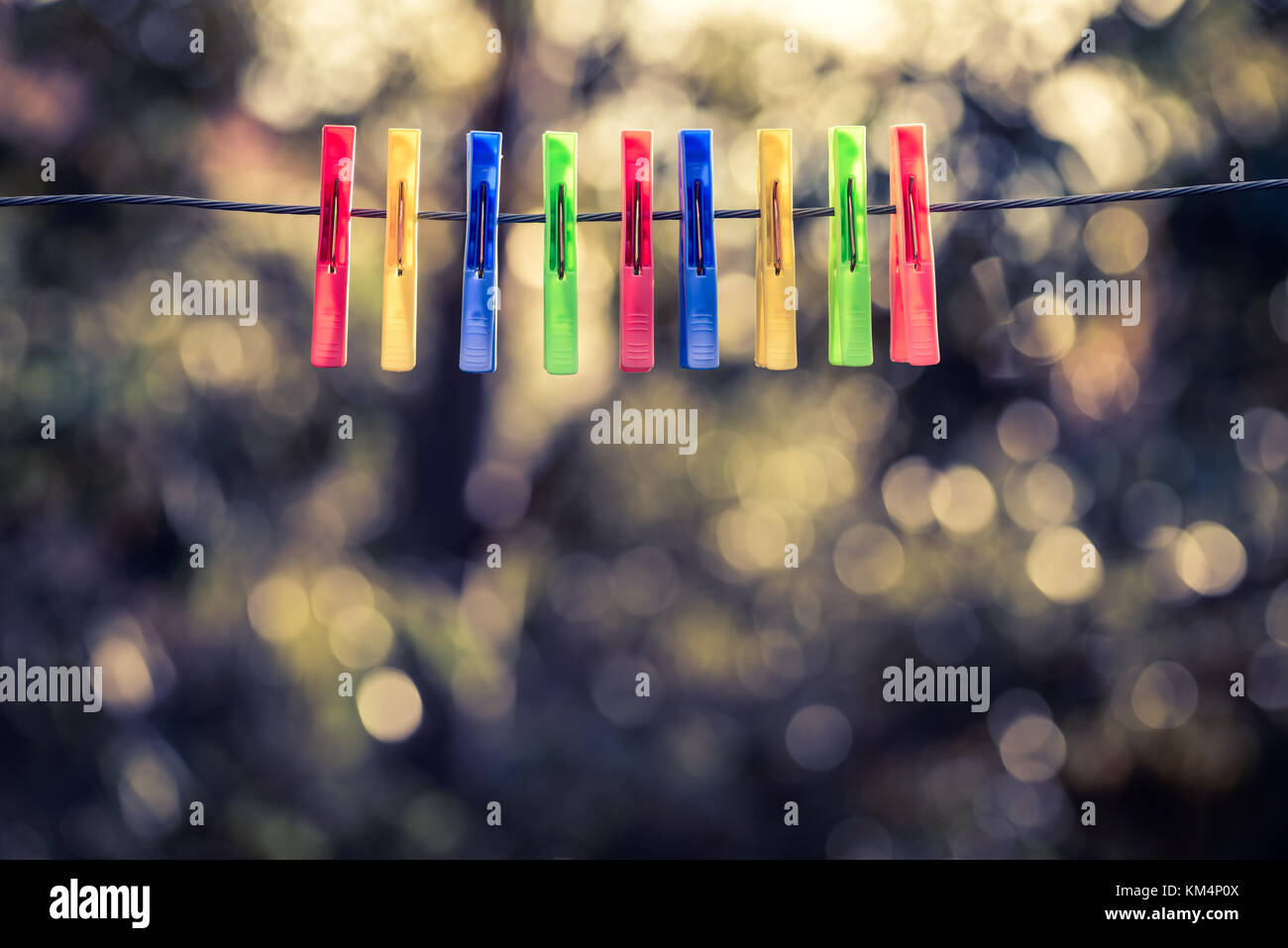 Colorful pegs hanging on clothesline. Cross processing effect applied