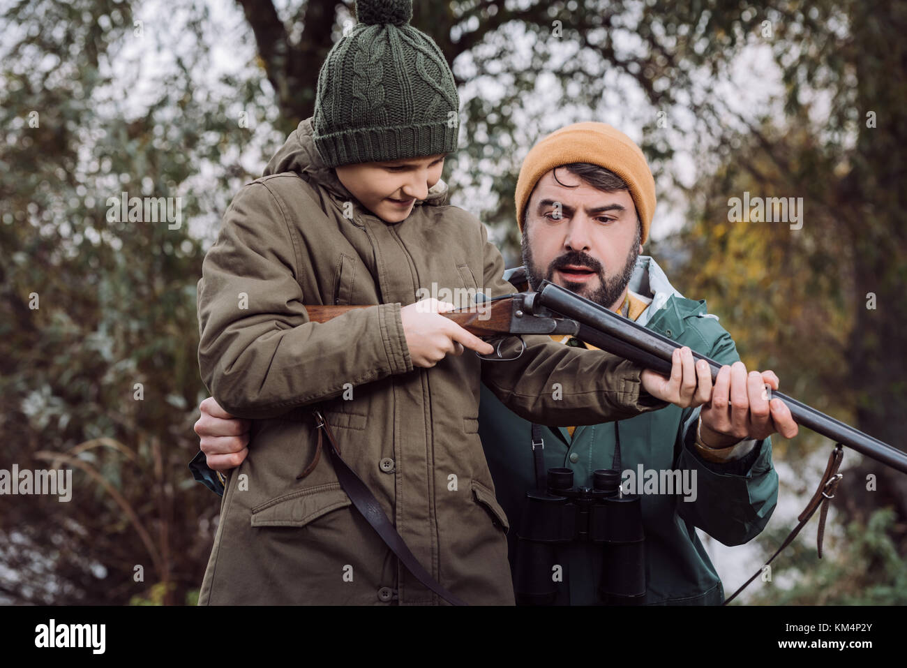 Father showing son how to load gun Stock Ph