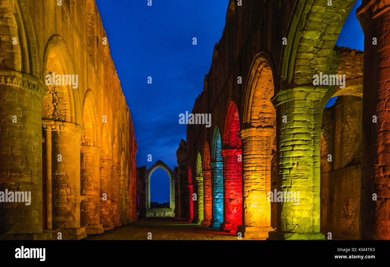 Arched buttresses picked out in colourful lights at dusk in the ancient