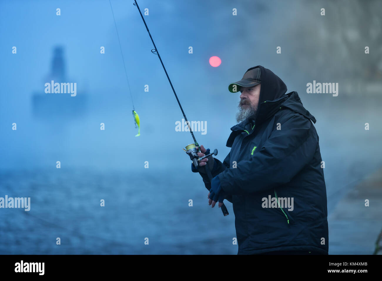 Alone fisherman, trying to catch fish in early morning. Urban fishing