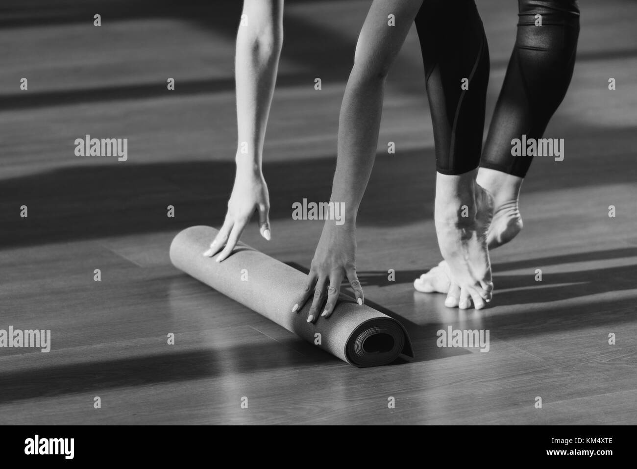 Woman Rolling Out Yoga Mat Stock Photo Alamy