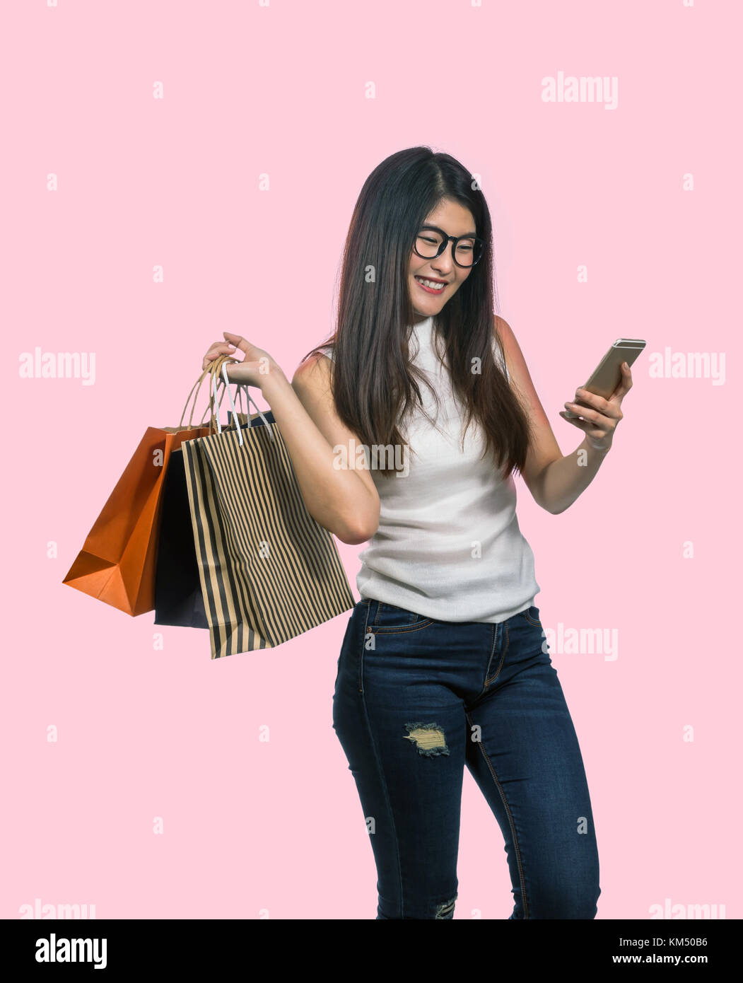 lifestyle indoors portrait of young happy and beautiful Asian Korean woman  shopping and using mobile phone at luxury bag shop walking around the store  Stock Photo - Alamy