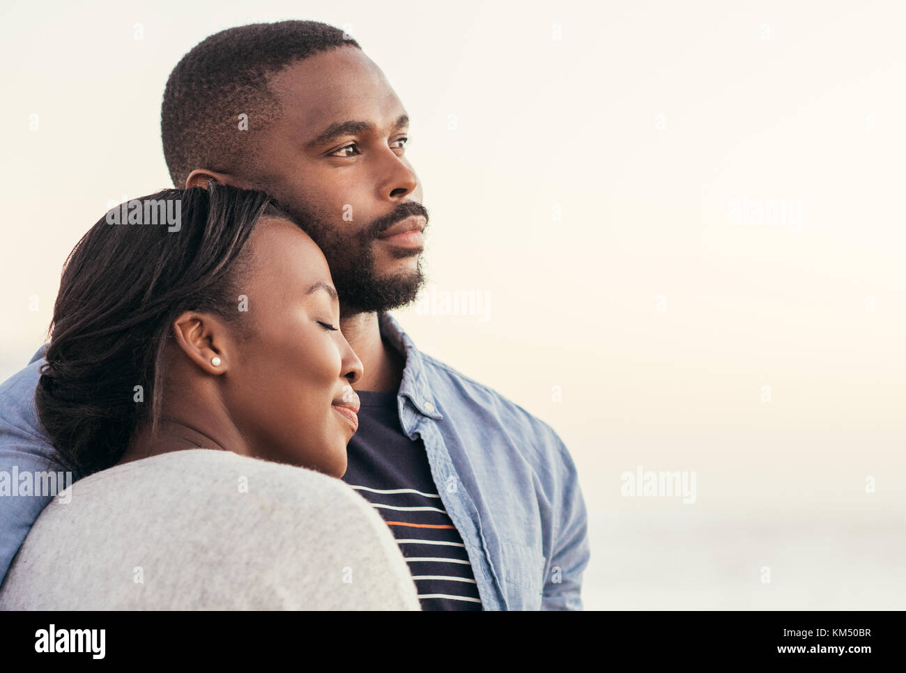 Young African couple enjoying a sunset at the beach Stock Photo