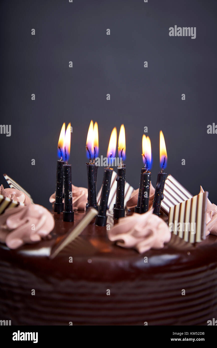 Chockolate birthday cake with candles on black background closeup Stock ...
