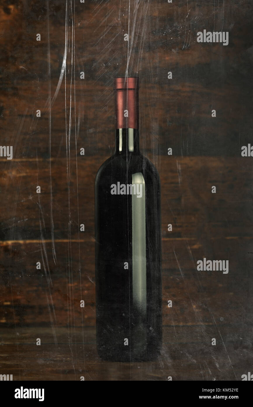 closed bottle of red wine on a wooden background, space for text Stock Photo
