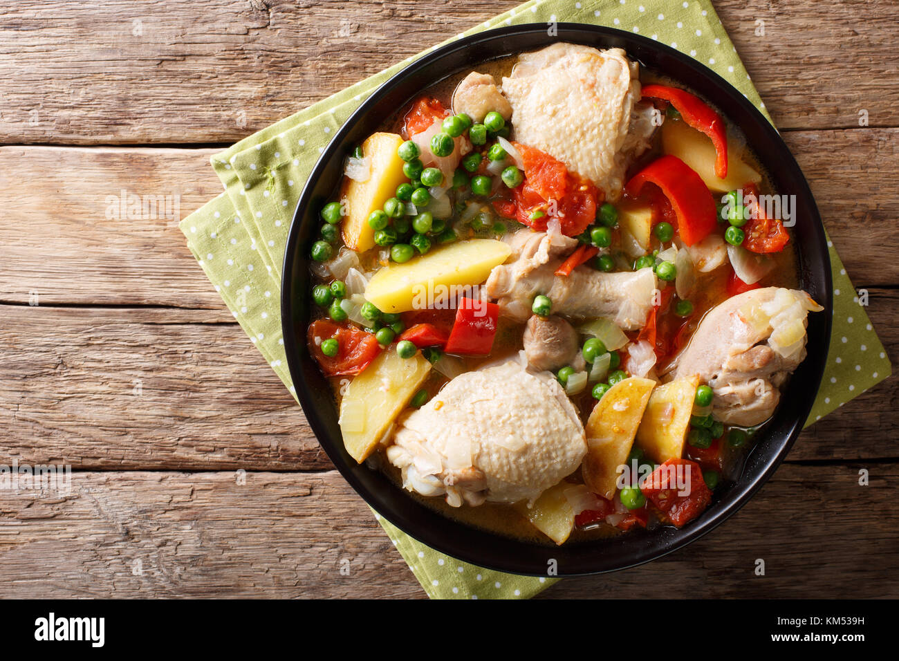Chicken meat stewed with vegetables and spices close-up in a bowl on the table. horizontal top view from above Stock Photo