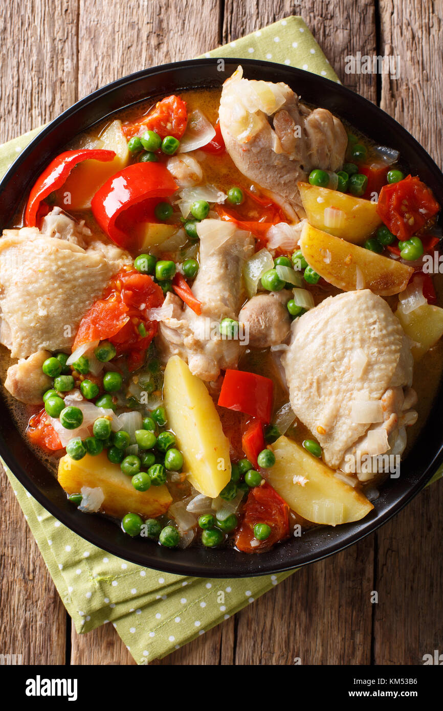 Filipino Afritada: slices of chicken with vegetables close-up in a bowl on the table. Vertical top view from above Stock Photo