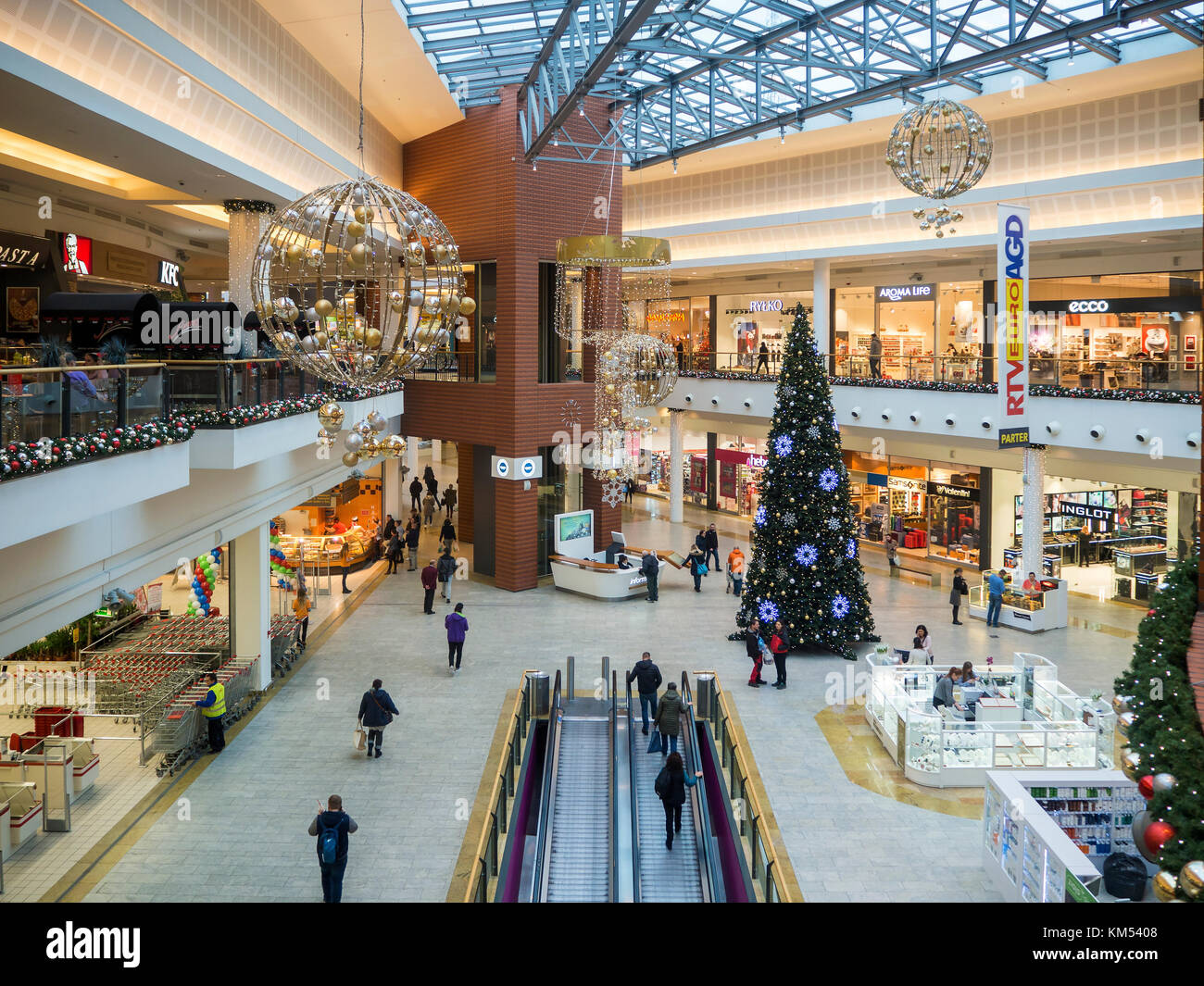 Christmas decoration, Christmas tree and people shopping in multilevel  modern hypermarket Bonarka in Cracow, Poland Stock Photo